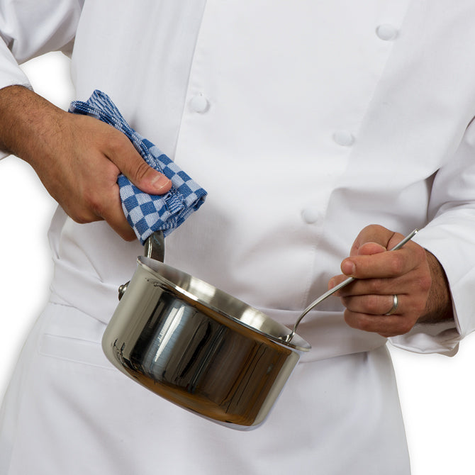 Professional chef holding pot with Blue JB prince Kitchen Towel, stiffing with a Gray Kunz Spoon on white silo background.