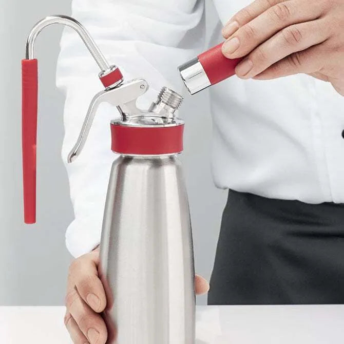 B949 Isi rapid infusion accessories being attached to whip cream maker on white background.