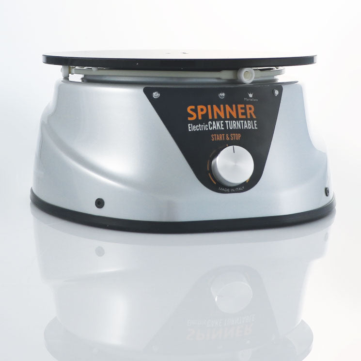 Black and Silver electric cake spinner at an angle on a white background. 