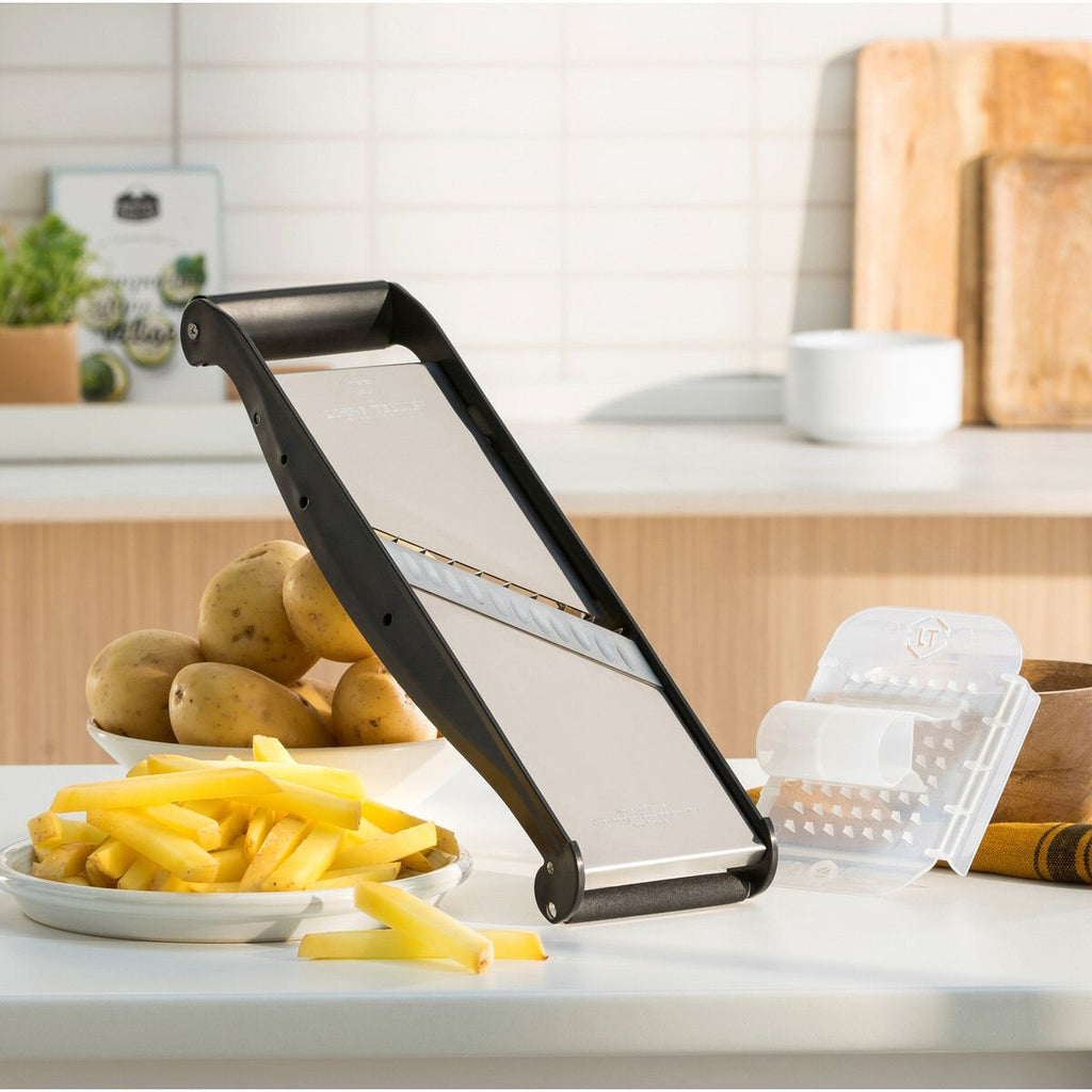 Sliced potatoes on a kitchen counter with a mandoline slicer