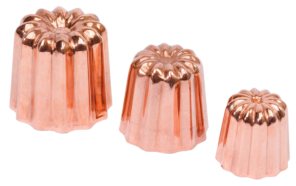 Set of three rcopper canele molds on a white background.
