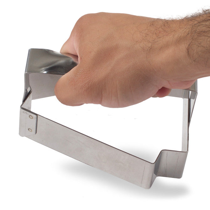 Base Cutter for Triangle Tart hand held on white background.