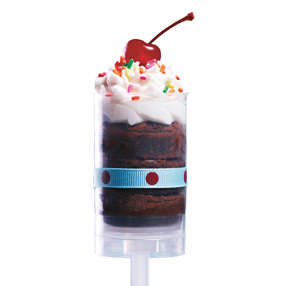 Item R746, Clear Push Up With Lid, shown with chocolate confectionery, topped with whip cream, sprinkles and cherry inside, shot on a white silo background.