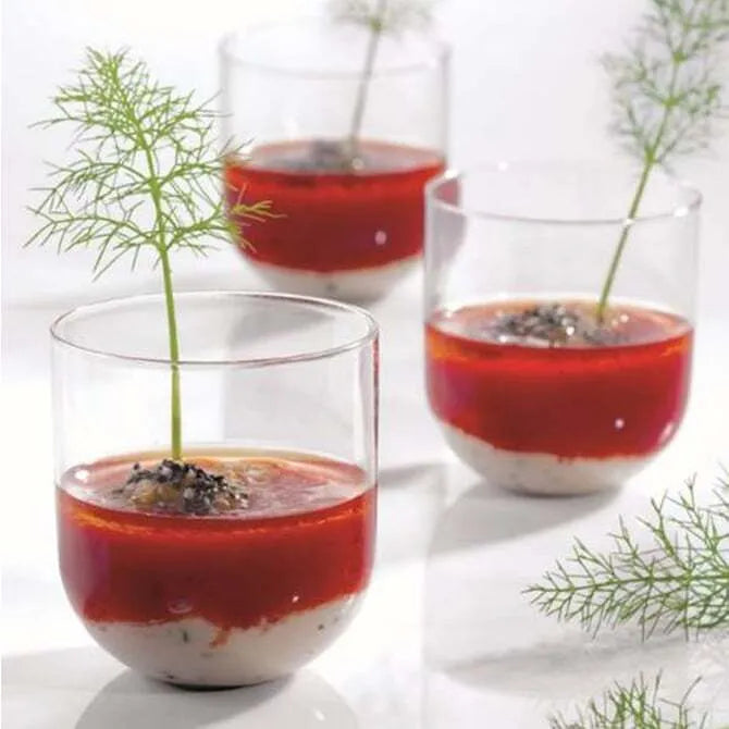 3 Plastic Tumblers shown full with half white, half red pastry, plated with green garnish shot on white silo background.