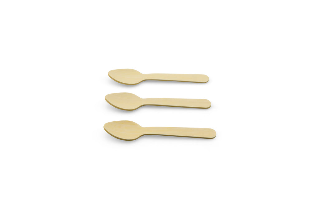 Three beige bamboo spoons placed on a plain background.