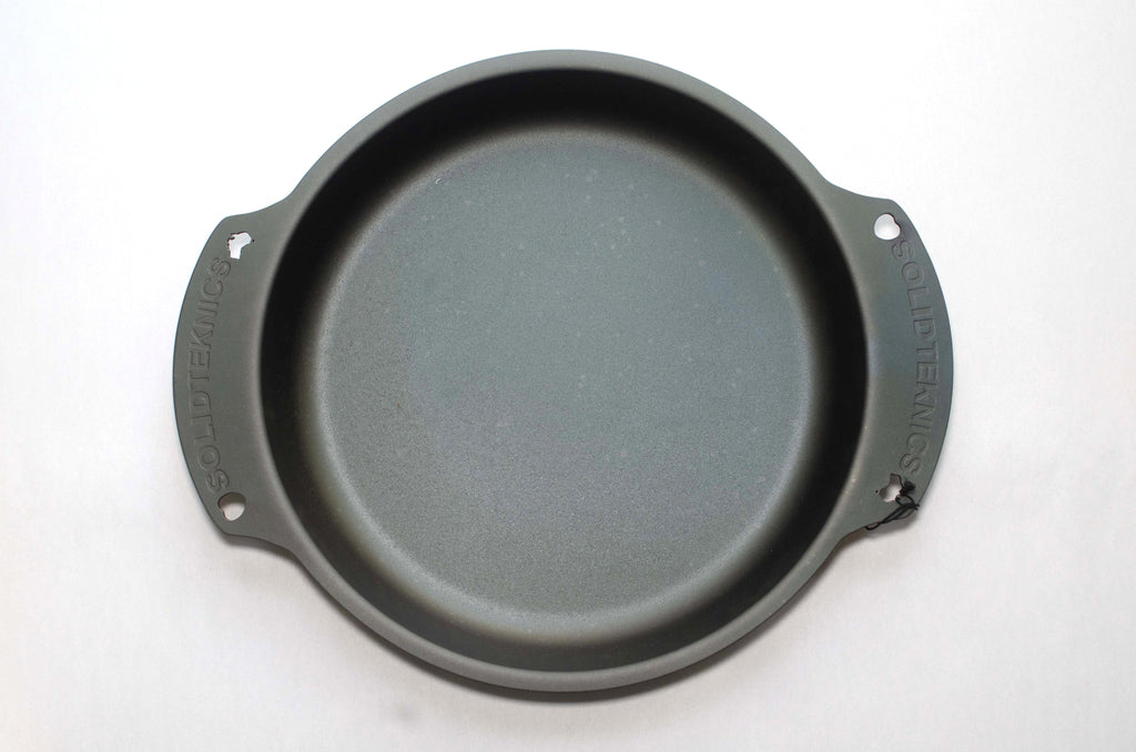 Two handle Seasoned black carbon steel skillet on a white background. 