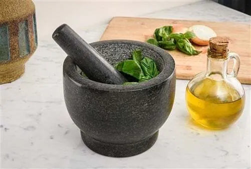 UA276 Mortar and Pestle showing spices in bowl on white table.
